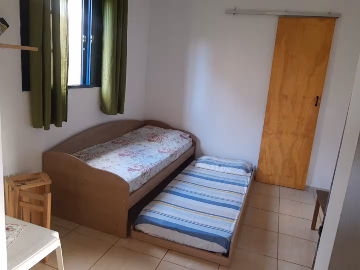 Quarto com cama de solteiro e cama auxiliar no Sítio São Jorge em Piedade