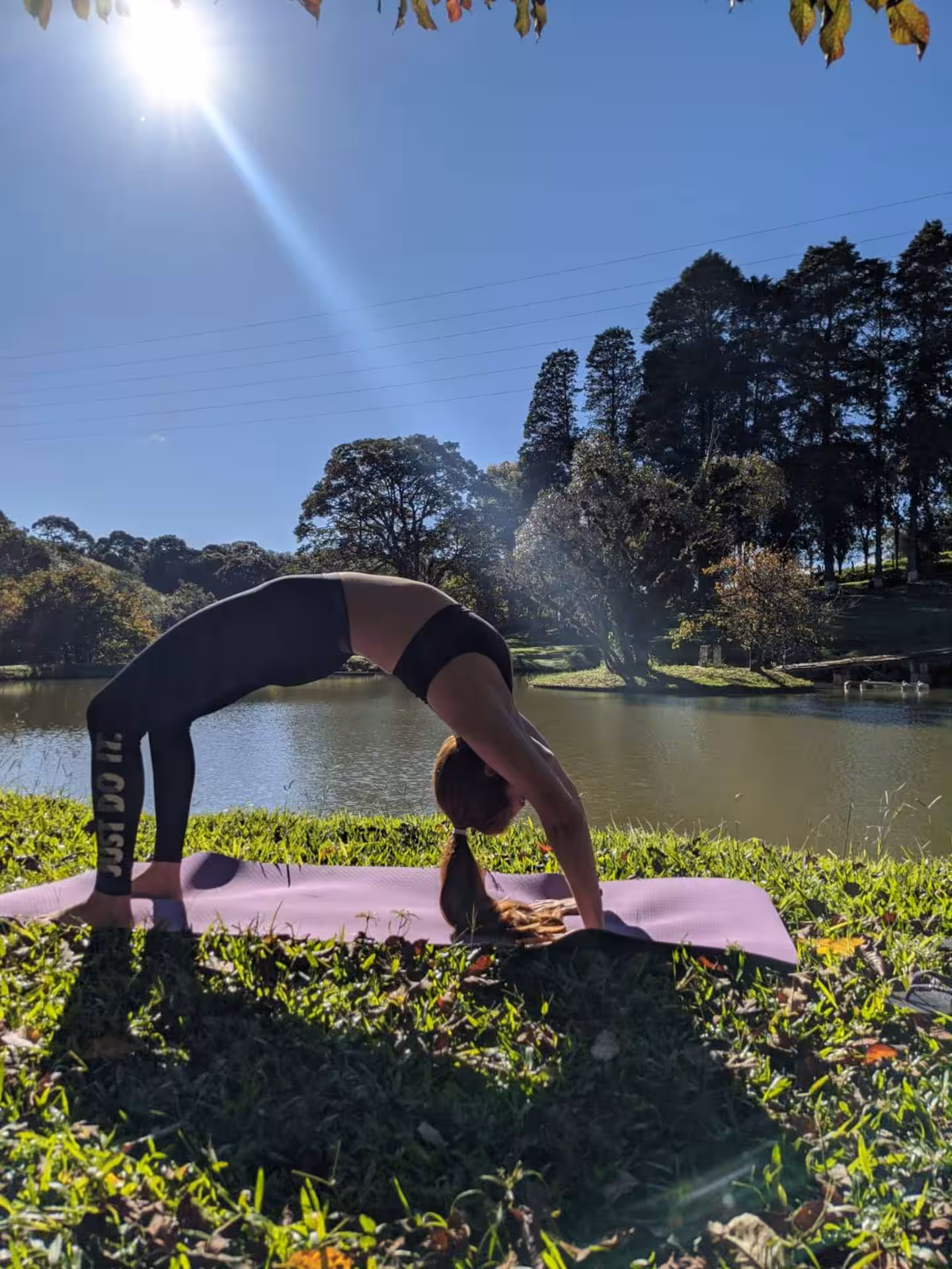 Prática de yoga na grama à beira do lago no Sítio São Jorge em Piedade